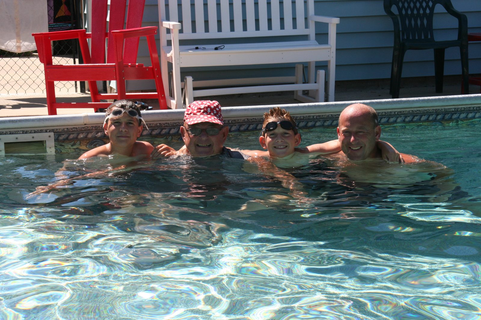 Justin with family in a backyard pool on a summer day
