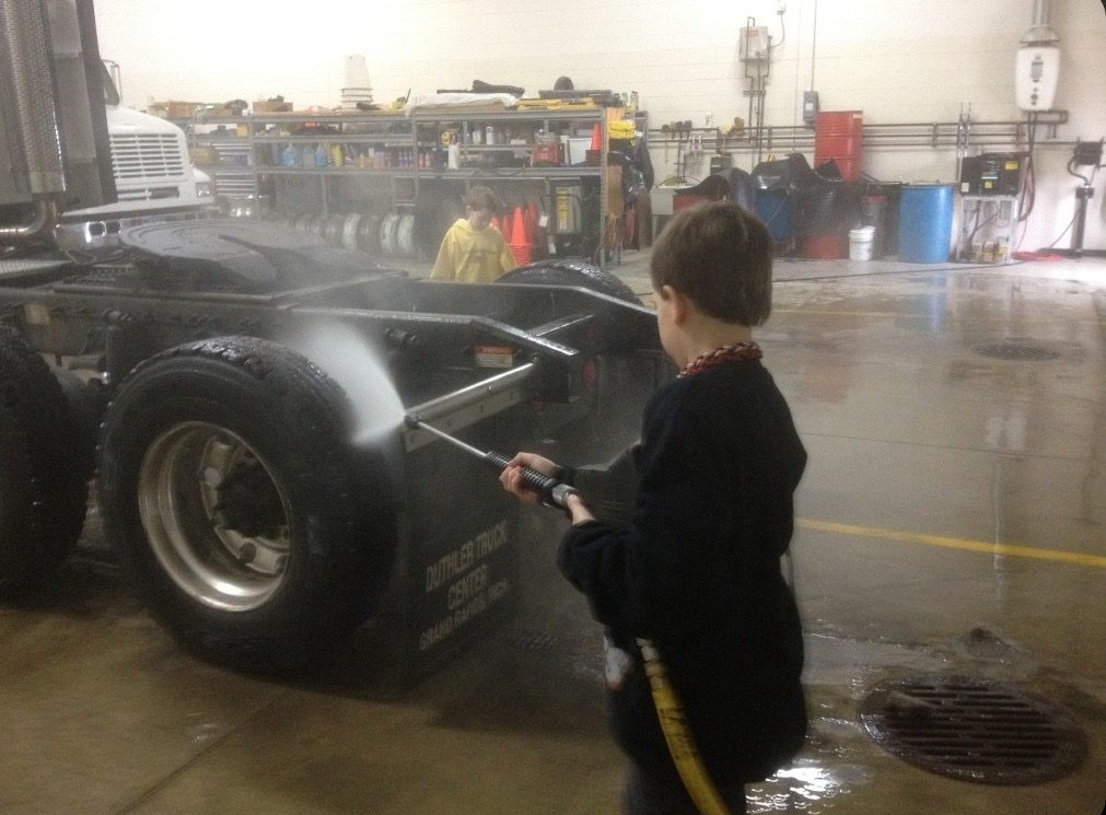 Justin pressure-washing the underside of a semi truck