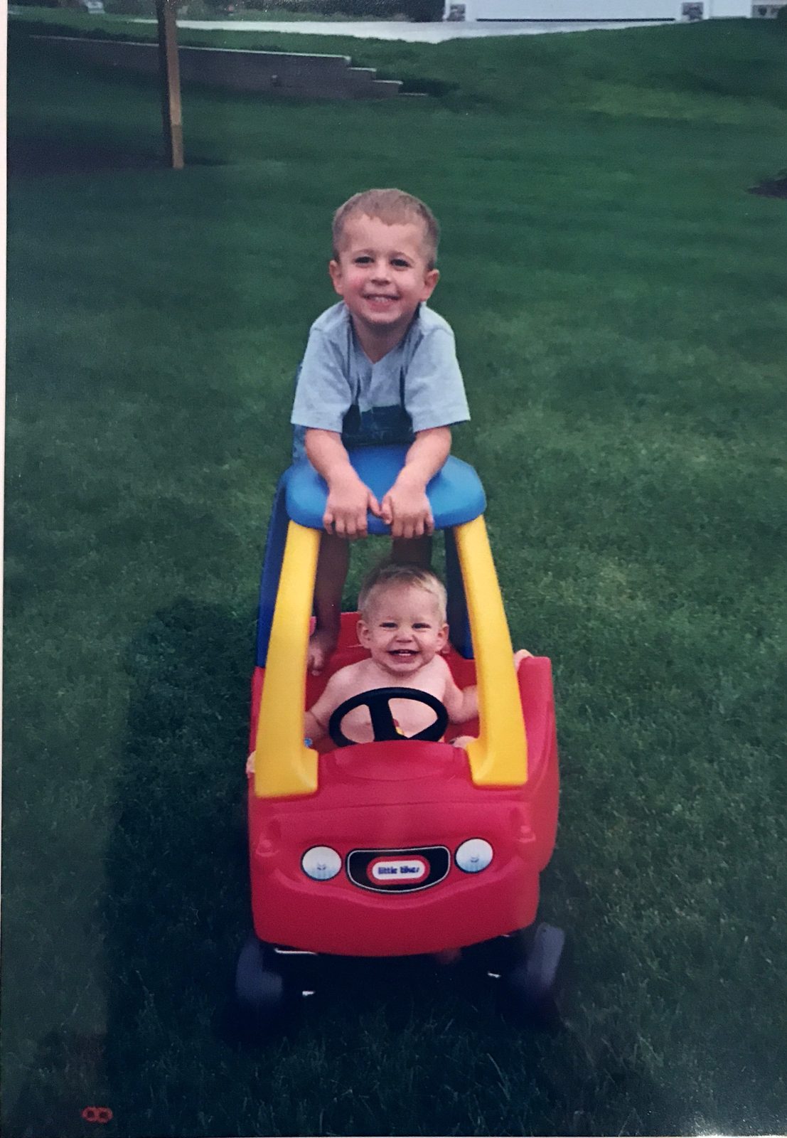 Justin as a young kid with his little brother on a toy car
