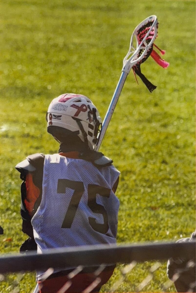 Justin in lacrosse goalie gear, number 75, on the field